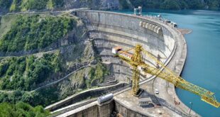 Cantiere edile su una diga con gru gialla, simbolo per avviare un’impresa edile