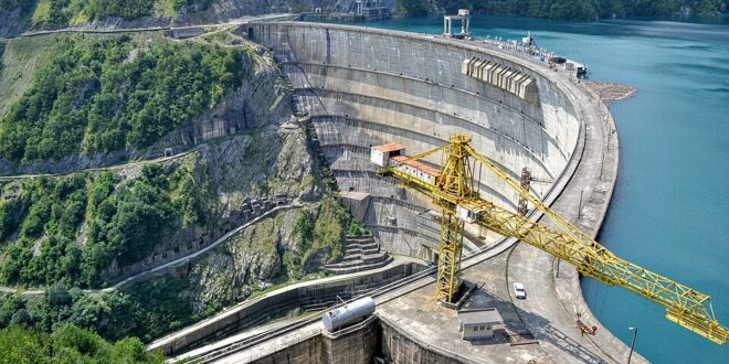 Cantiere edile su una diga con gru gialla, simbolo per avviare un’impresa edile